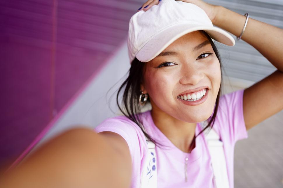 Free Image of Glad Asian female taking selfie 