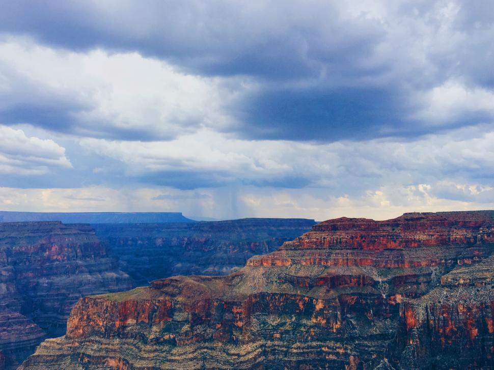 Free Image of A large canyon with clouds in the sky 