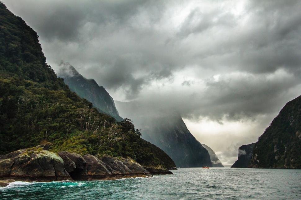 Free Image of A body of water with mountains and clouds 