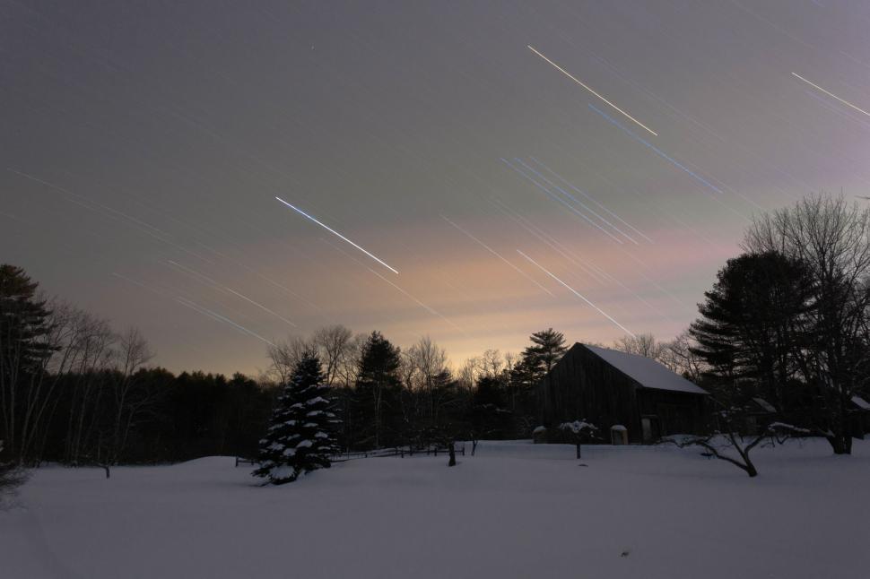 Free Image of A snow covered ground with a house and trees 
