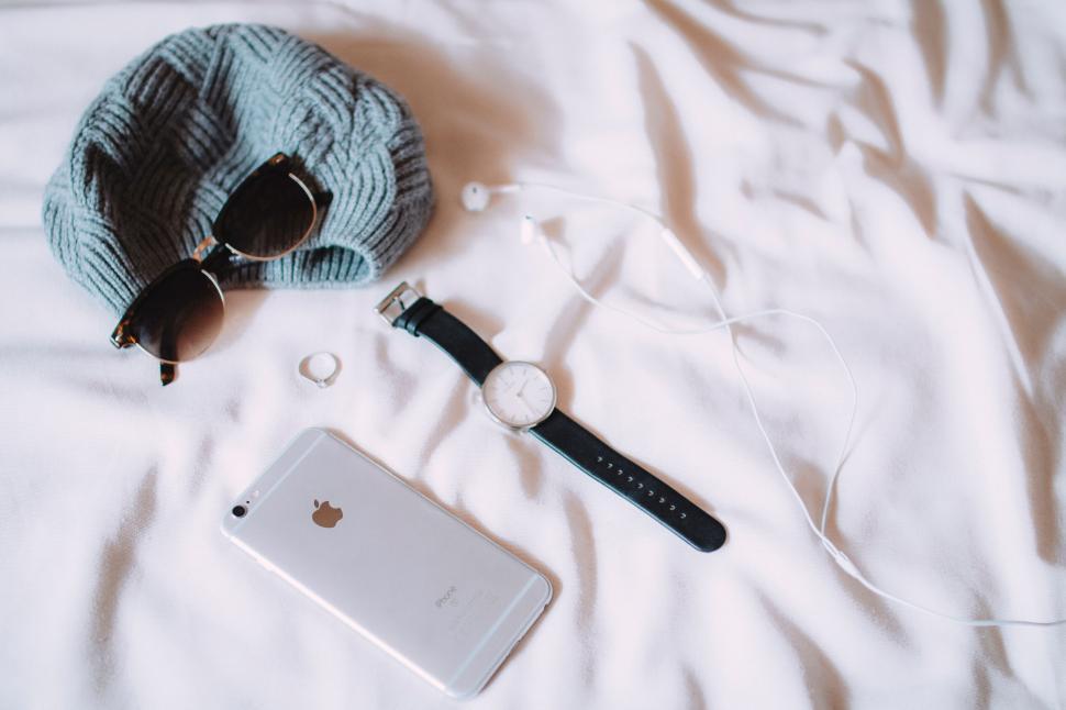 Free Image of A phone and sunglasses on a blanket 
