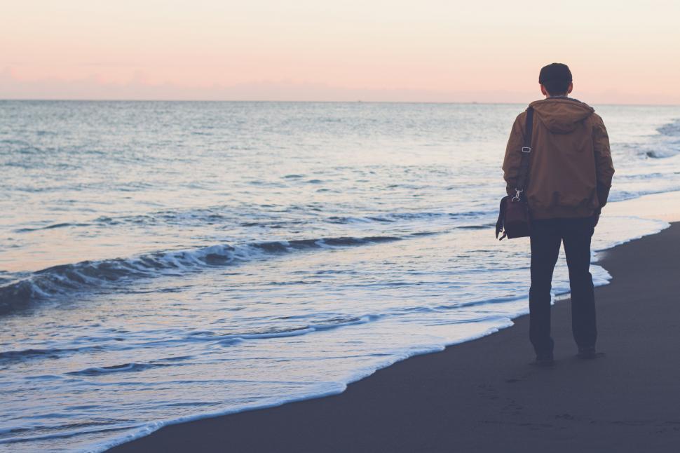 Free Image of A man walking on a beach 