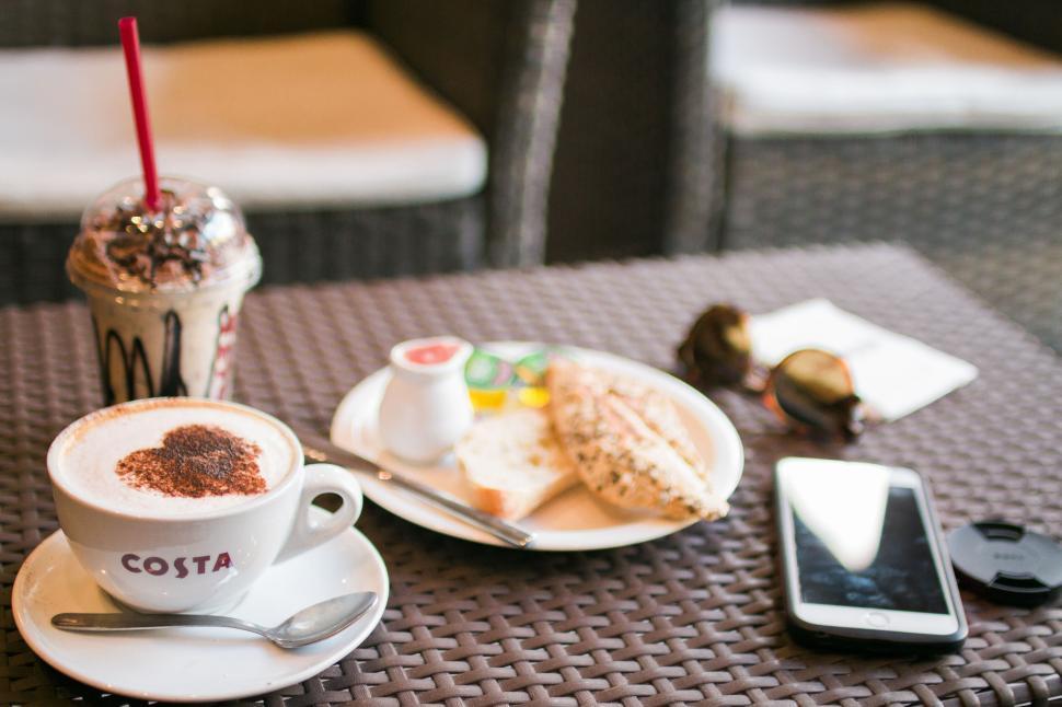 Free Image of A cup of coffee and a plate of bread on a table 