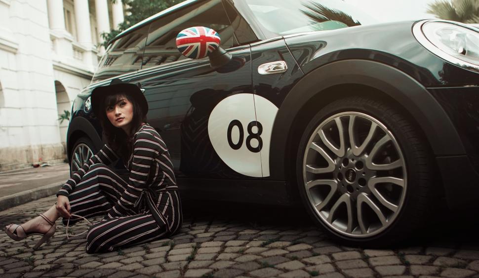 Free Image of A woman sitting next to a car 