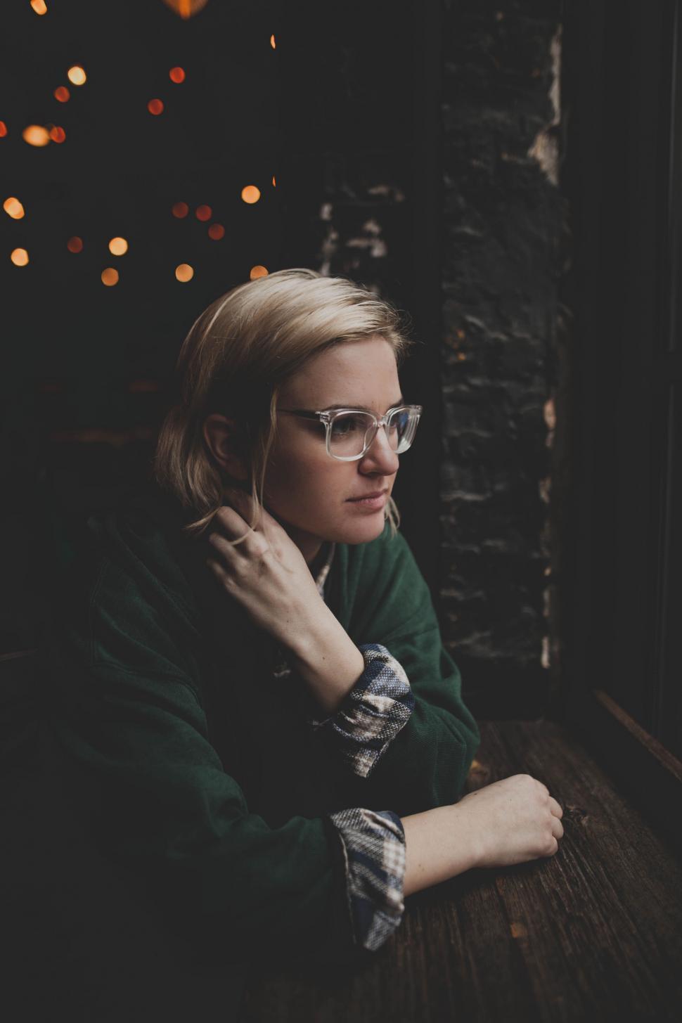 Free Image of A woman sitting in a window 