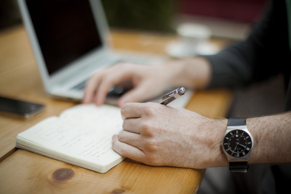 Free Image of A person writing on a notebook 
