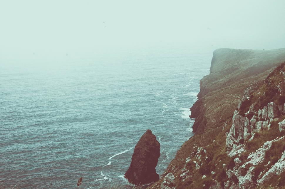 Free Image of A cliff with a body of water 