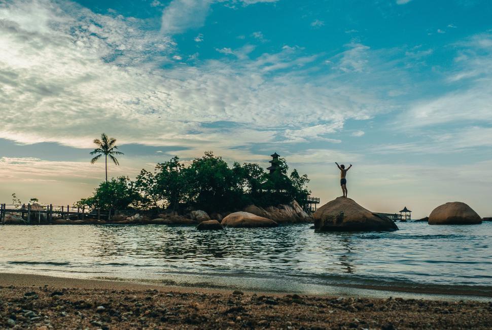 Free Image of A person standing on a rock in the water 