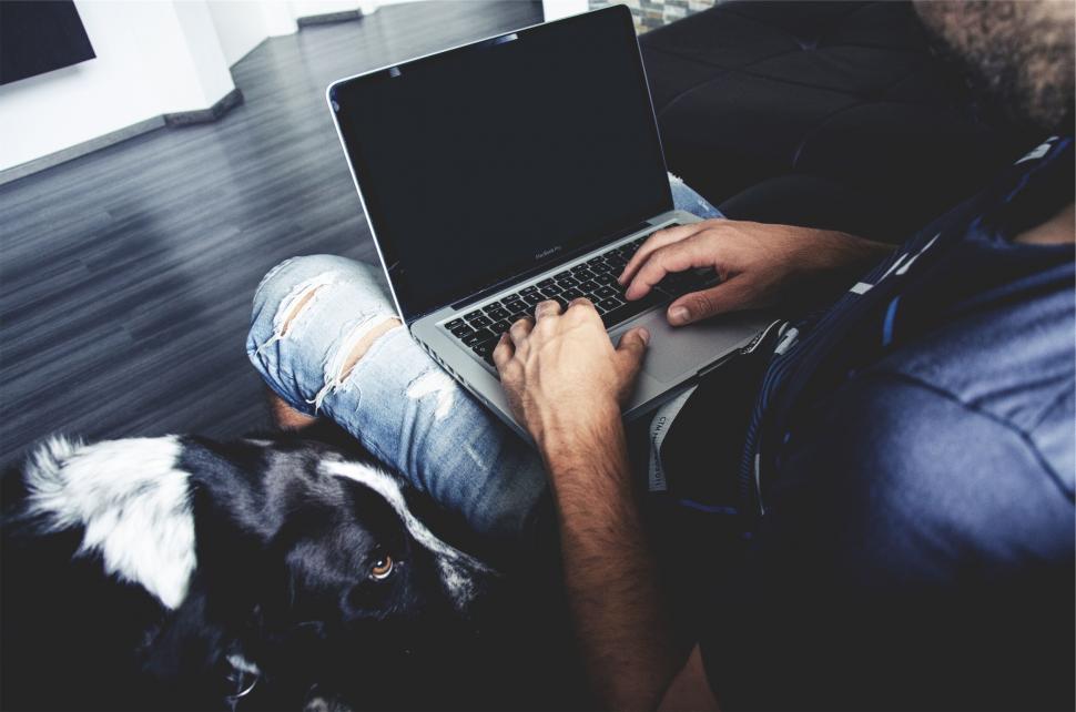 Free Image of A person sitting on a couch using a laptop 
