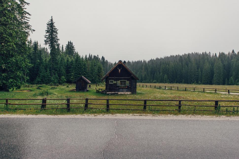 Free Image of A house in a field with trees in the background 