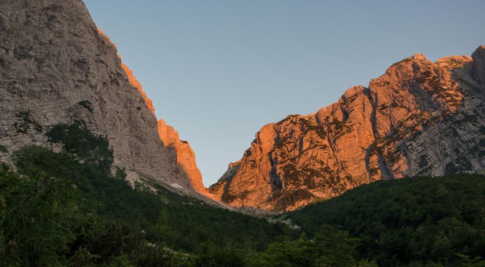 Free Image of A mountain range with trees and blue sky 