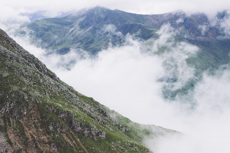 Free Image of A mountain with clouds above it 
