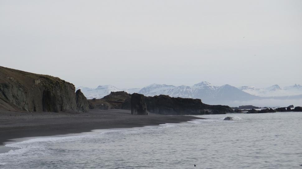 Free Image of A rocky beach with mountains in the background 