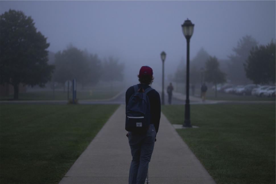 Free Image of A person walking on a sidewalk 