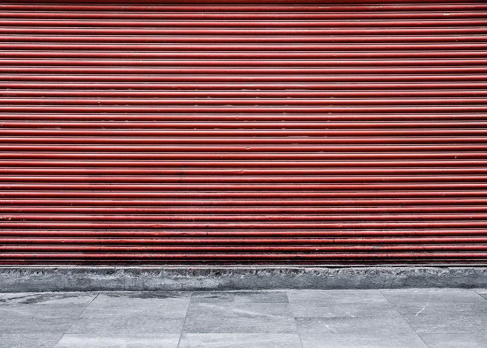 Free Image of Red Garage Door With Black and White Fire Hydrant 