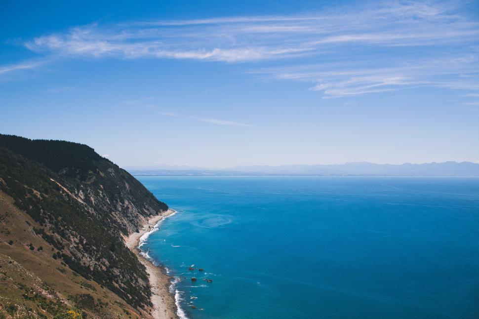 Free Image of A rocky cliff next to a body of water 