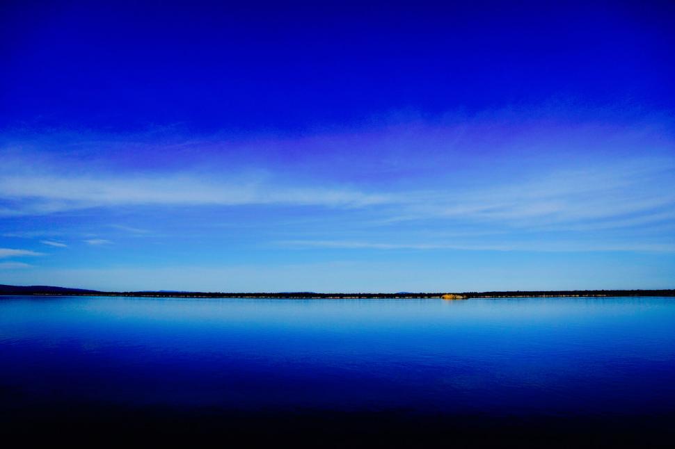 Free Image of A body of water with a blue sky and clouds 