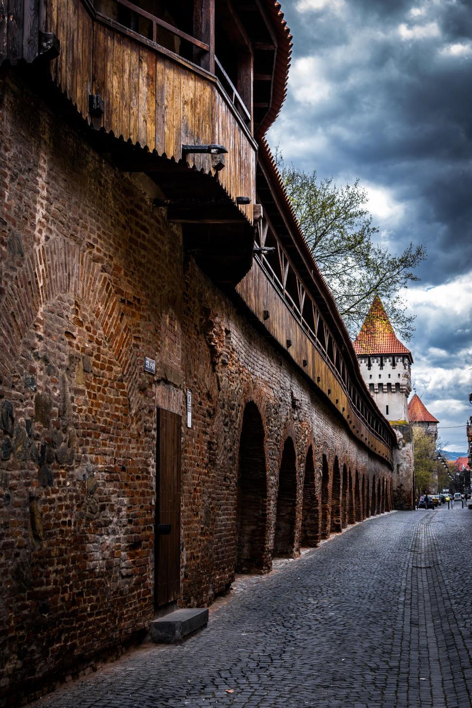 Free Image of A brick wall with a bridge and a tower 