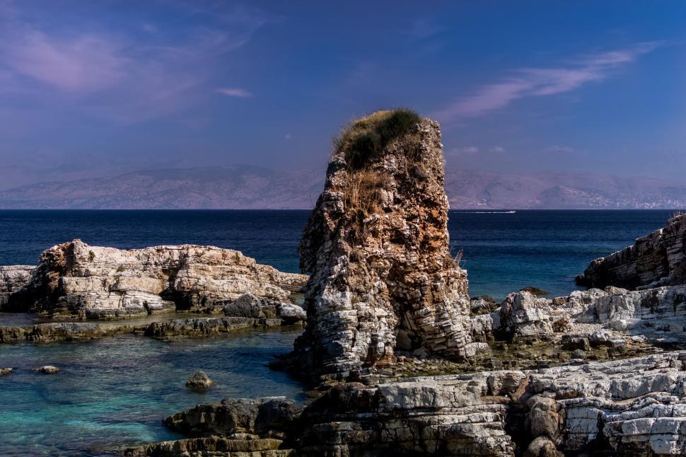 Free Image of A rocky beach with a large rock formation 