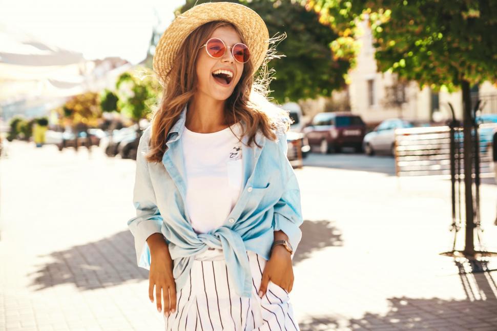 Free Image of A woman wearing a straw hat and sunglasses 