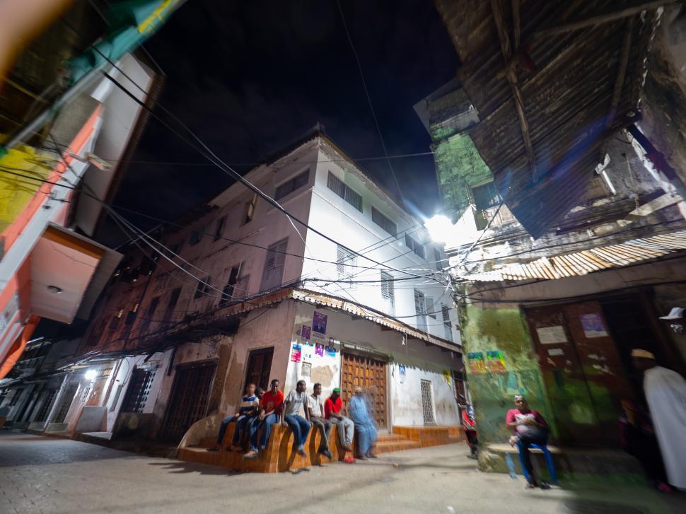 Free Image of A group of people sitting on a bench outside a building in Africa 