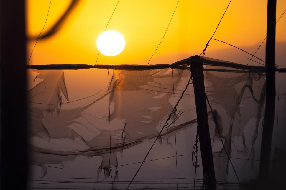 Free Image of A sun setting over a fence 