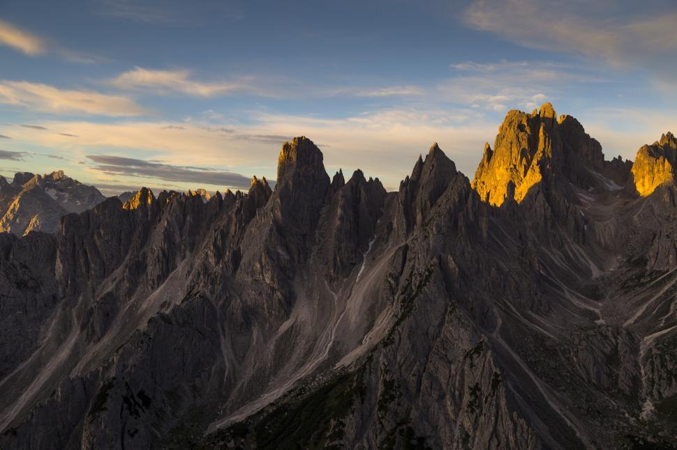 Free Image of A mountain range with the sun shining on it 