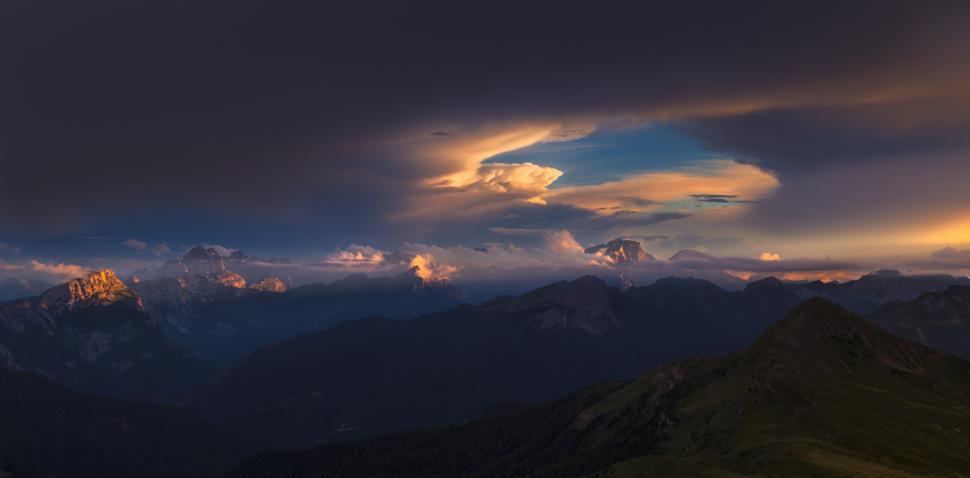 Free Image of A mountain range with clouds and a blue sky 