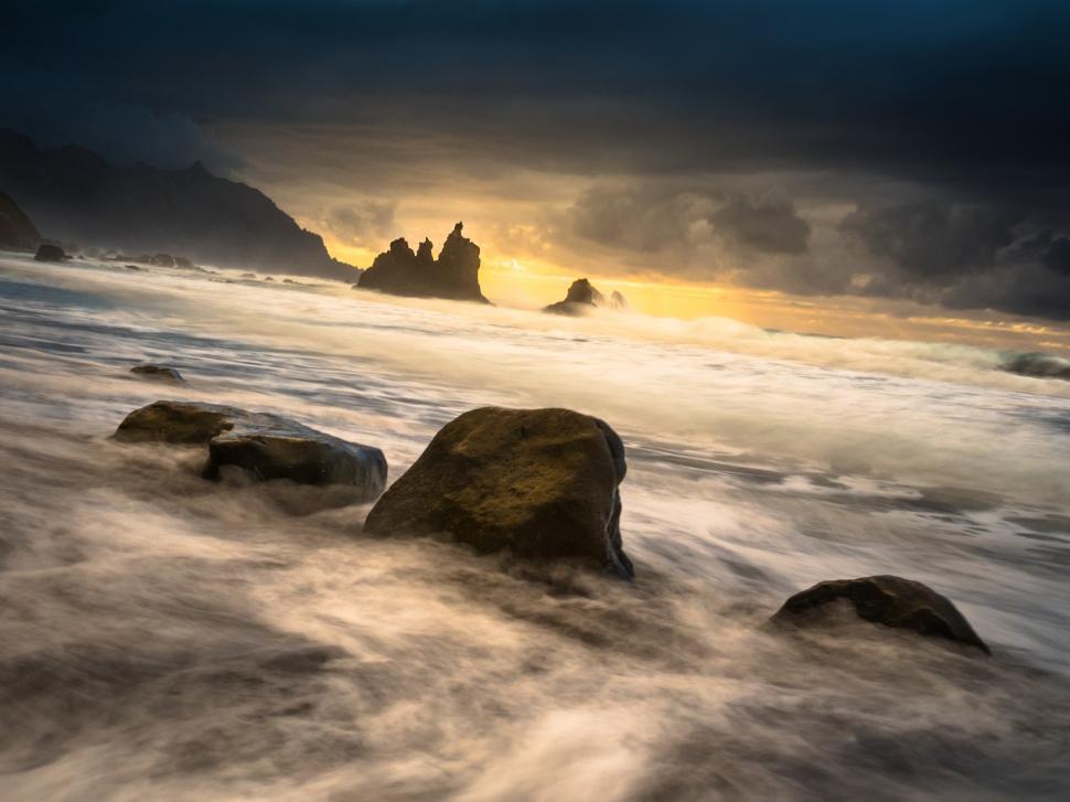 Free Image of A waves crashing onto rocks on a beach 