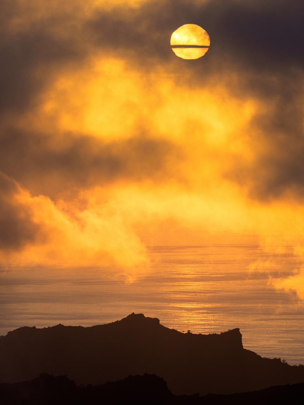 Free Image of A sun rising over a body of water 