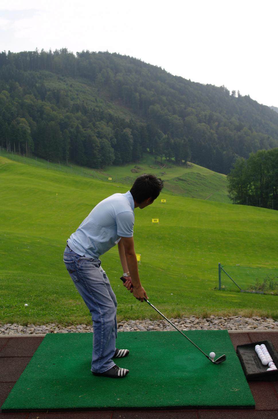 Free Image of Man Hitting Golf Ball With Golf Club 