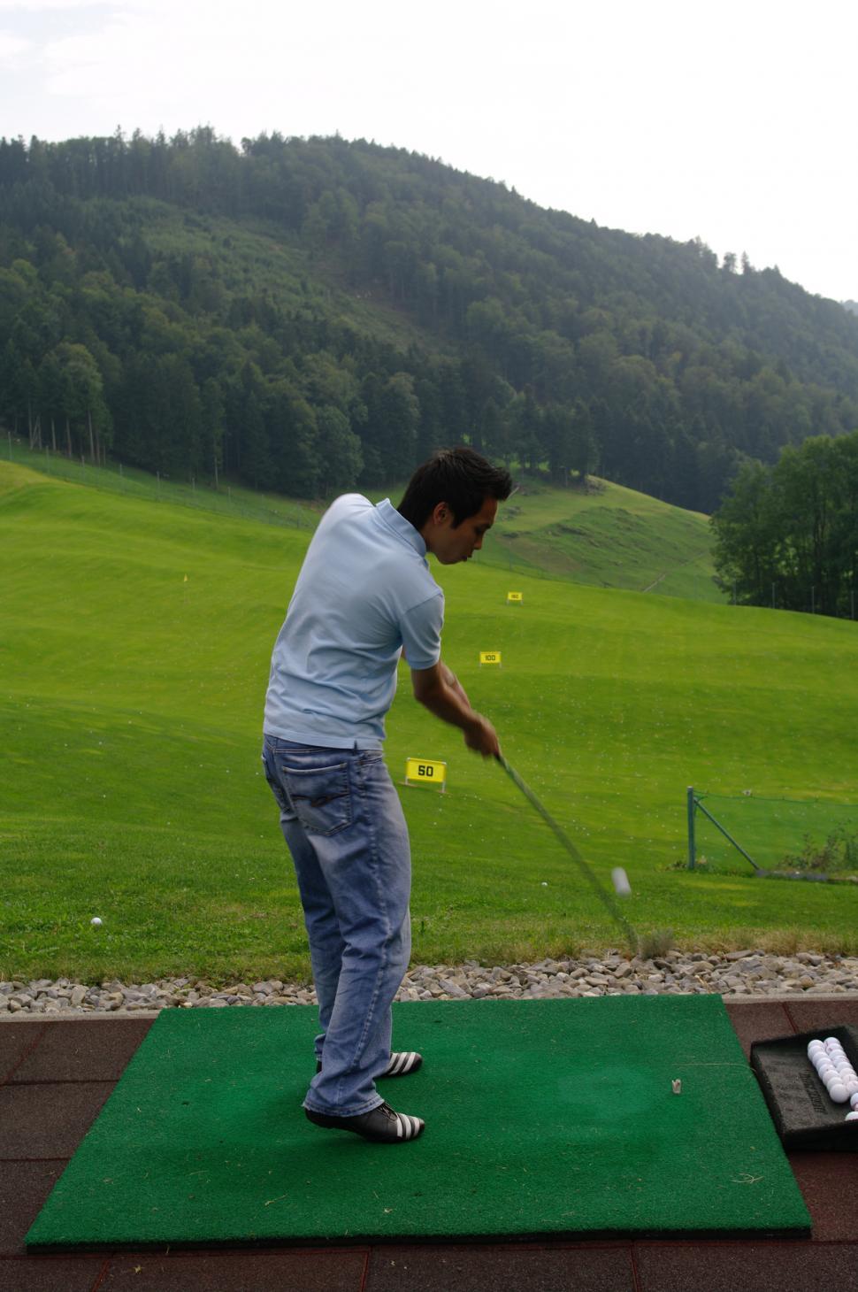 Free Image of Man Hitting Golf Ball With Golf Club 