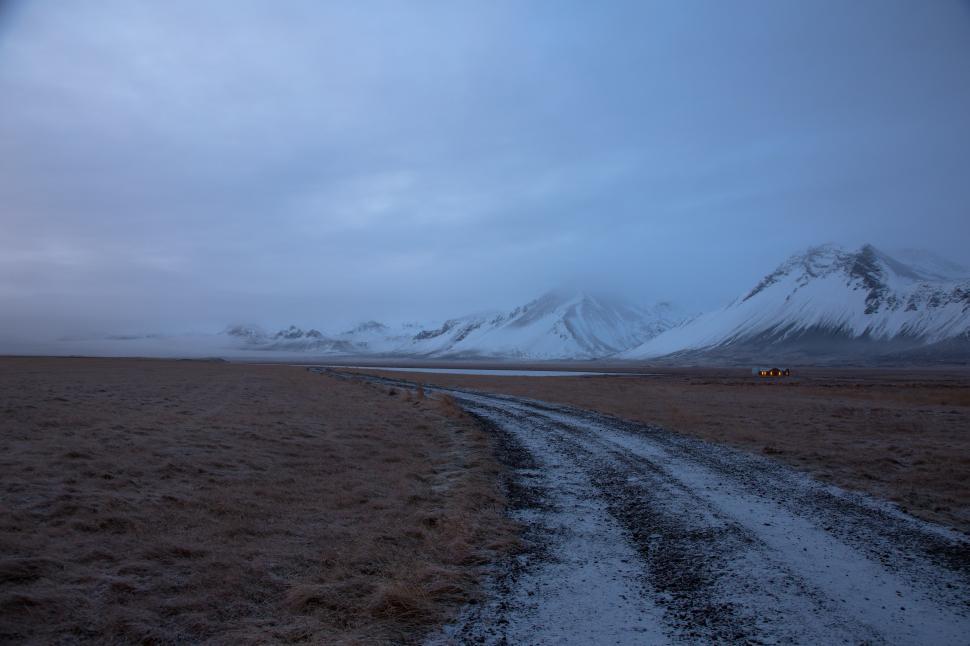 Free Image of A dirt road through a snowy field 