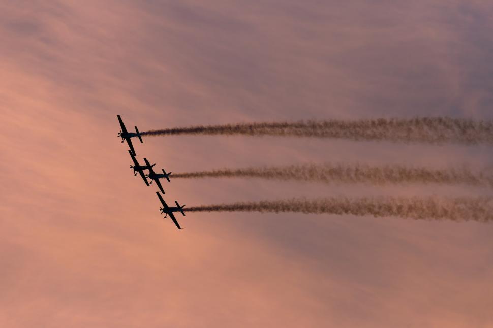 Free Image of A group of airplanes flying in formation with smoke trails 