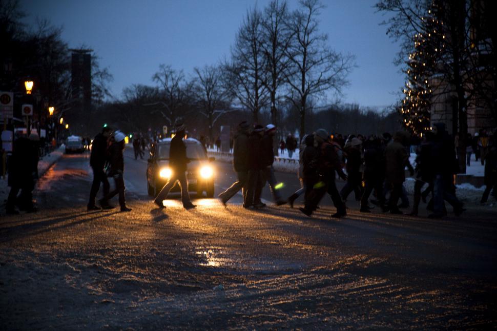 Free Image of A group of people walking on a street with lights 