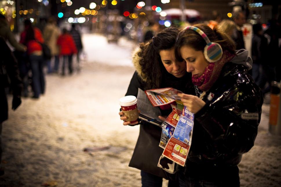 Free Image of A group of women looking at a map and drinking coffee 