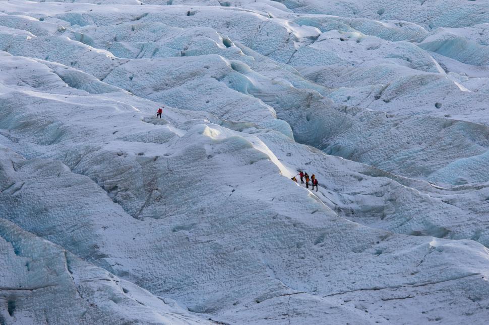 Free Image of A group of people walking on a snowy mountain 