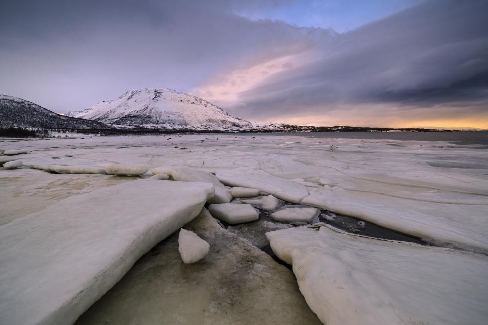 Free Image of A snowy landscape with a mountain in the background 