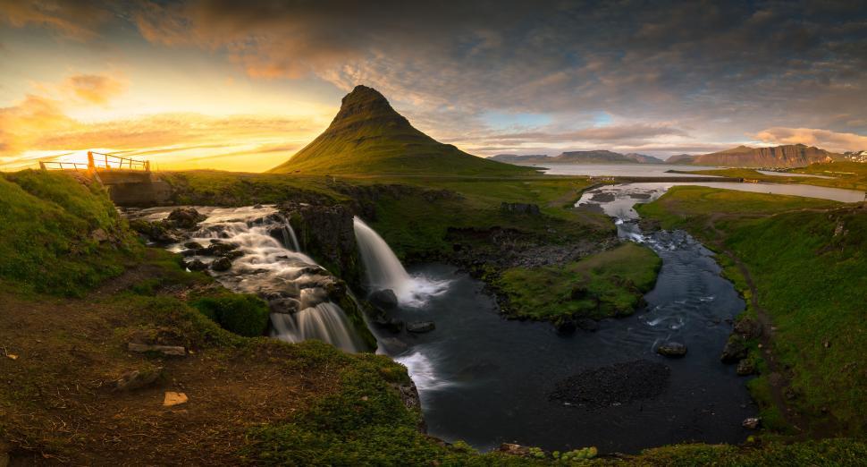Free Image of A waterfall and a river in a grassy area 