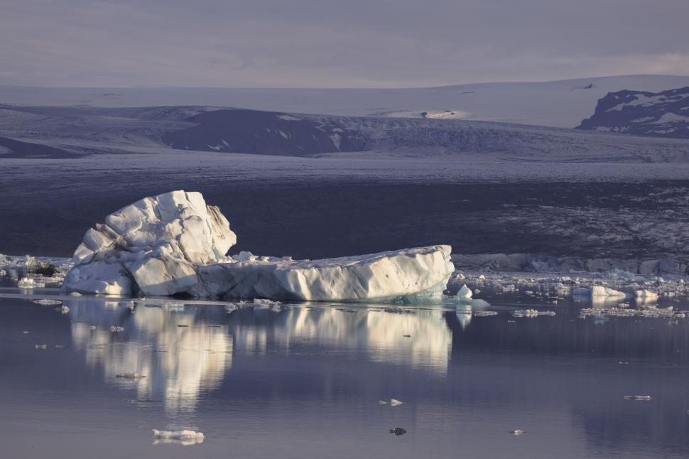Free Image of Icebergs in a body of water with mountains in the background 