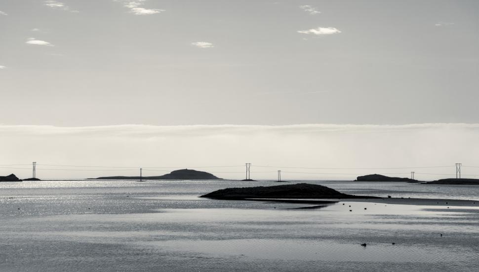 Free Image of A body of water with land and power lines in the distance 