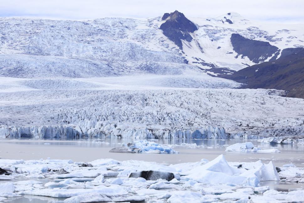 Free Image of A glacier with snow and mountains in the background 