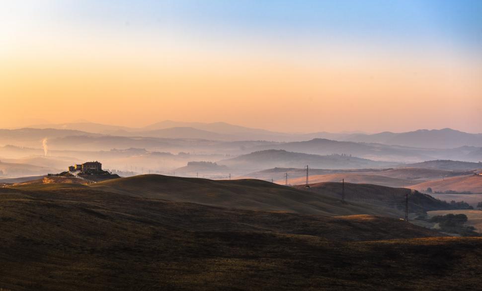 Free Image of A landscape of hills with power lines and buildings 