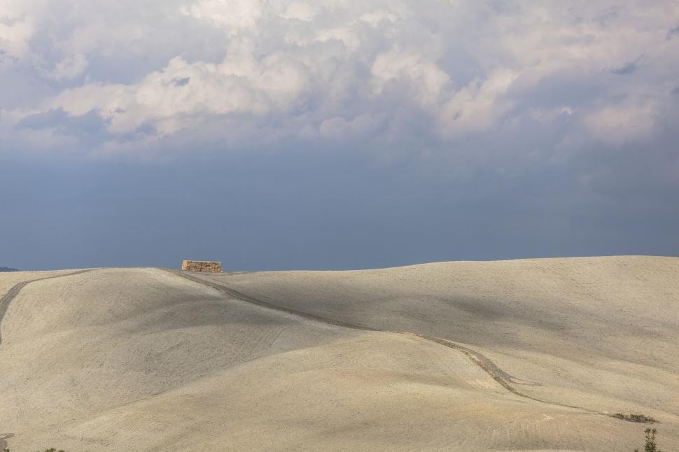 Free Image of A large sandy hill with a building on top 
