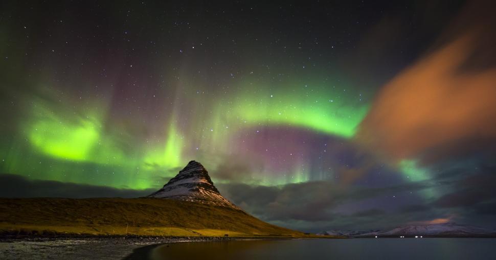 Free Image of A mountain with green lights in the sky 