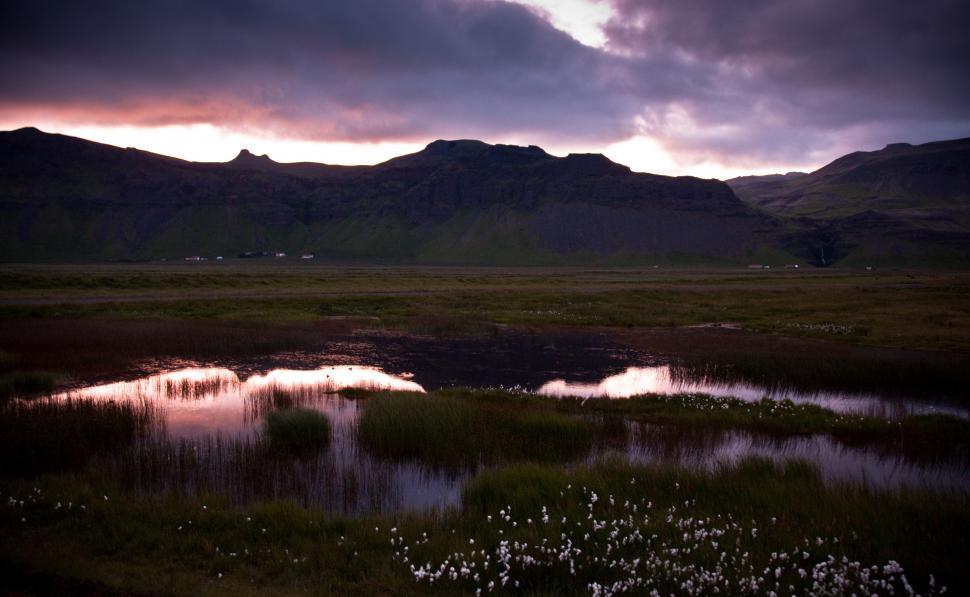 Free Image of A landscape with a lake and mountains in the background 