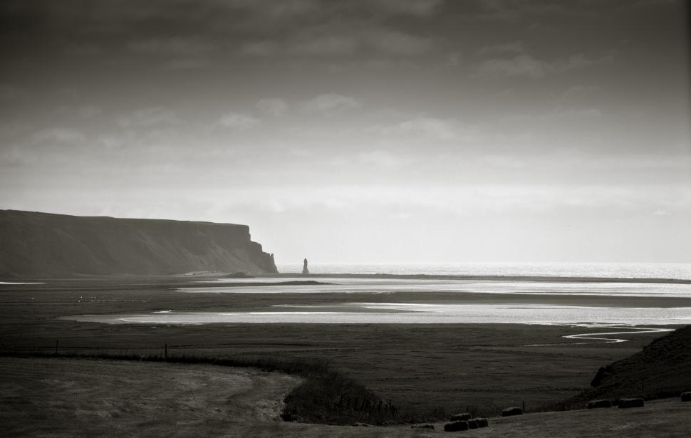 Free Image of A landscape with a body of water and a cliff 