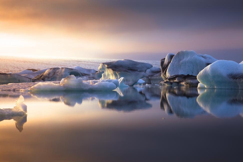 Free Image of Icebergs in the water with a cloudy sky 