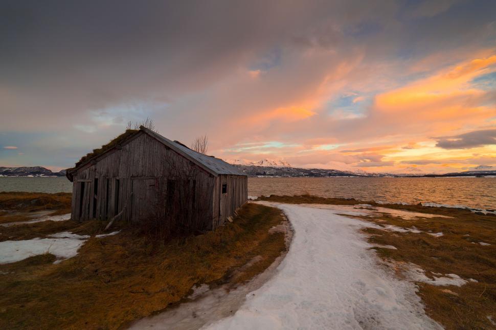 Free Image of A wooden building next to a body of water 