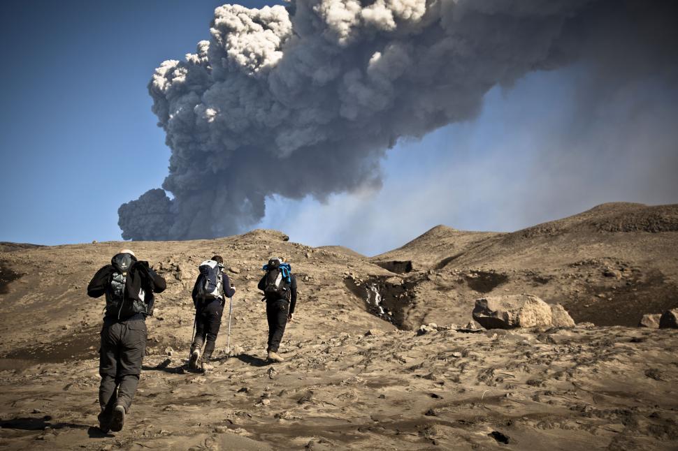 Free Image of People walking on a dirt road with a cloud of smoke 